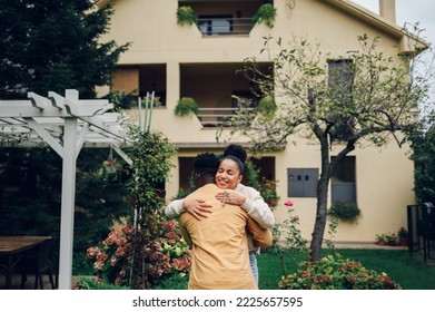 Happy diverse couple bought their new home and standing in front of it and showing keys. First time real estate owners. Hispanic woman hugging african american man and posing in front of the house. - Powered by Shutterstock