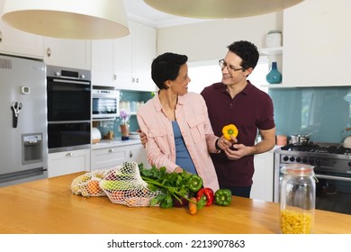 Happy Diverse Couple Cooking Dinner Together, Smiling And Embracing In Kitchen. Spending Family Time At Home.