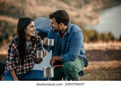 Happy diverse couple enjoying vacation sitting by the fireplace - Powered by Shutterstock