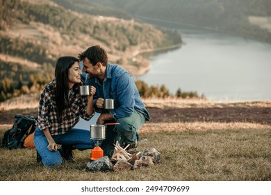 Happy diverse couple enjoying vacation sitting by the fireplace - Powered by Shutterstock