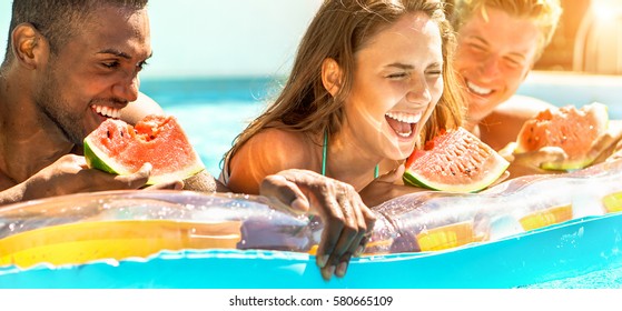 Happy Diverse Culture Friends Eating Watermelon At Swimming Pool Party - Young People Having Fun In Summer Ibiza Holidays - Friendship And Tropical Concept  - Focus On Center Girl - Warm Filter