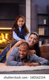 Happy Diverse Family Having Fun At Home On Floor, Lying On Each Other.