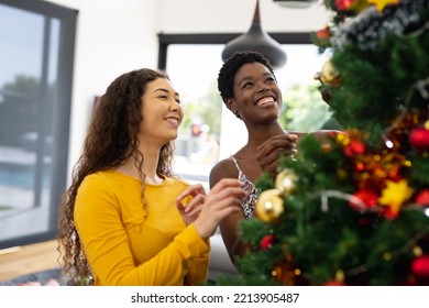 Happy diverse female friends decorating christmas tree at christmas. Christmas, celebration, friendship, inclusivity and lifestyle concept. - Powered by Shutterstock