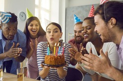 Happy Diverse Friends Group And Home Birthday Party Celebration Concept. Cheerful Woman Blowing Candles On Cake. Overjoyed People Clapping Hands Having Fun Together. Indoor Leisure Entertainment