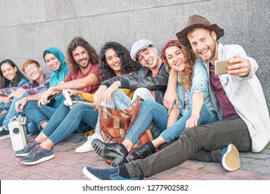 Happy diverse friends taking selfie with mobile smart phone camera - Millennial young people having fun making photos for new social network trends - Multiracial, technology, youth lifestyle concept - Shutterstock ID 1277902582