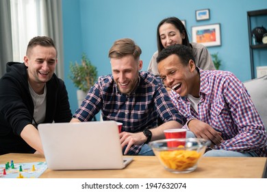 Happy Diverse Friends Watching Funny Video, Laughing At Joke, Using Laptop, Having Fun Together, Sitting On Couch, Looking At Computer Screen, Students Colleagues Working On Online Project