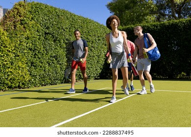 Happy diverse group of friends arriving together at tennis court. Active lifestyle, summer, leisure time, sport, competition and friendship. - Powered by Shutterstock