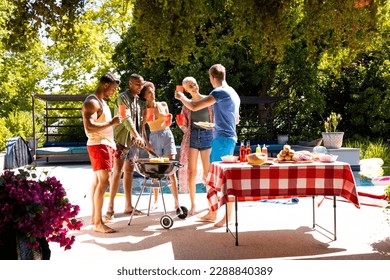 Happy diverse group of friends having pool party, barbecuing in garden. Lifestyle, friendship, party and summer. - Powered by Shutterstock