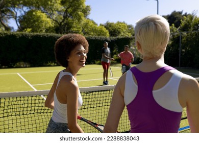 Happy diverse group of friends playing tennis at tennis court. Active lifestyle, summer, leisure time, sport, competition and friendship. - Powered by Shutterstock