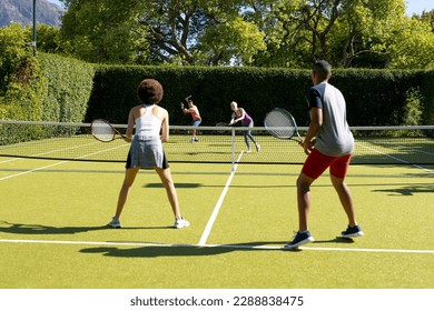 Happy diverse group of friends playing tennis at tennis court. Active lifestyle, summer, leisure time, sport, competition and friendship. - Powered by Shutterstock