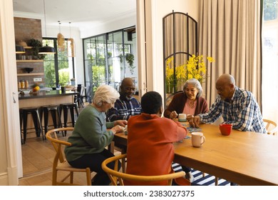 Happy diverse group of senior friends playing with jigsaw puzzles in sunny dining room at home. Retirement, friendship, wellbeing, activities, togetherness and senior lifestyle, unaltered. - Powered by Shutterstock