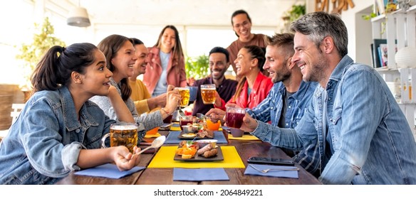 Happy Diverse Large Group Of Multicultural Friends Having Salty Breakfast Brunch Together At Bar Restaurant Indoors. Convivial People Talking Sitting On A Table At Home Having Fun. Lifestyle Concept