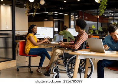 Happy diverse male and female colleagues in discussion using tablet in casual office meeting. Casual office, teamwork, disability, inclusivity, business and work, unaltered. - Powered by Shutterstock