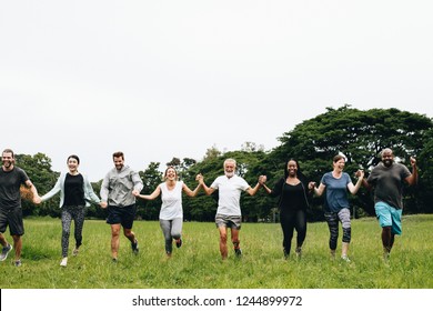 Happy Diverse People Holding Hands In The Park