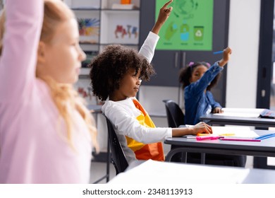 Happy diverse schoolchildren sitting at desks in school classroom. Education, childhood, elementary school and learning concept. - Powered by Shutterstock