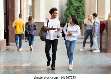 Happy diverse students walking in college campus during break and talking, copy space - Shutterstock ID 1465673534