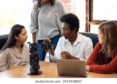 Happy diverse teens students group building robotic  hand using tablet computer. Building And Learning To Program electric Robot. STEM coding engineering class. - Powered by Shutterstock