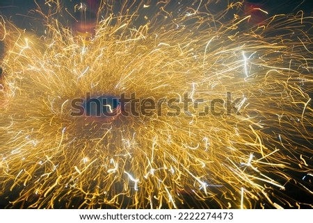 Happy Diwali Celebration with exploding of Firecracker on floral pattern. Ground spinner firework cracker exploding during Indian Festival of Lights. Long exposure shot captured in low light.