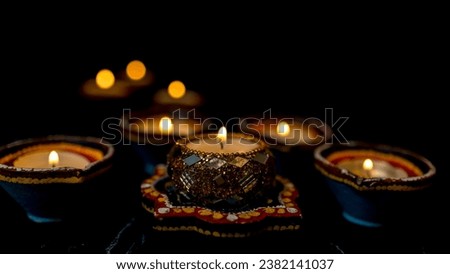 Happy Diwali - Clay Diya lamps lit during Dipavali, Hindu festival of lights celebration. Colorful traditional oil lamp diya on dark background. Copy space for text.