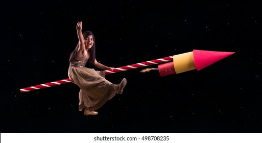 Happy Diwali Greeting Card Showing Cheerful Little Indian Small Girl Sitting On Big Firecracker Or Rocket And Flying In The Sky Filled With Stars