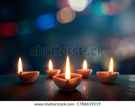 Happy Diwali, Lit diya lamp on an abtract background with shallow depth of field