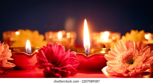 Happy Diwali. Traditional Indian festival of light. Burning diya oil lamps and flowers on red background. Banner format. - Powered by Shutterstock