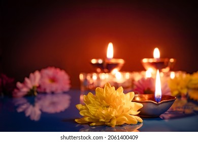 Happy Diwali. Traditional symbols of Indian festival of light. Burning diya oil lamps and flowers on red background. Copy space. - Shutterstock ID 2061400409