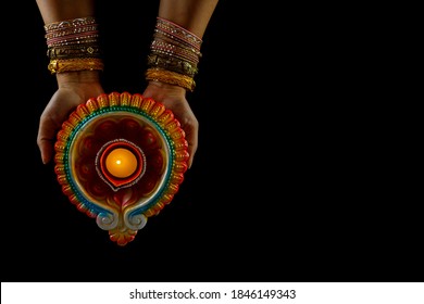 Happy Diwali - Woman Hands With Henna Holding Lit Candle Isolated On Back Background. Clay Diya Lamps Lit During Dipavali, Hindu Festival Of Lights Celebration