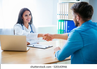 Happy Doctor Shaking Hand Of Her Healthy Patient