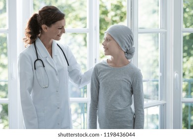 Happy Doctor Supporting Positive Child With Cancer Wearing Headscarf