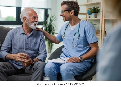 Happy doctor talking to senior male patient while being in a home visit. 