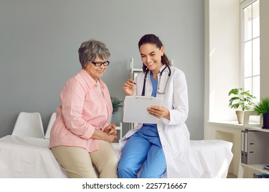 Happy doctor together with senior patient having fun at medical checkup at clinic. Smiling old woman and friendly physician sitting on medical couch looking at good analysis result. Medicine concept - Powered by Shutterstock