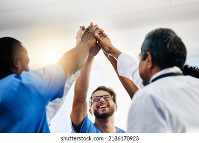 Happy doctors, medical professionals and team giving high five in celebration of success, wining and achievement at a hospital. Group of health experts showing support, teamwork and excitement - Powered by Shutterstock