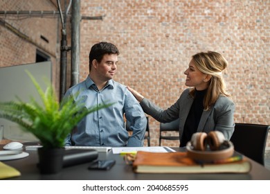 Happy down syndrome man with businesswoman colleague working in office, social inclusion and cooperation concept. - Shutterstock ID 2040685595