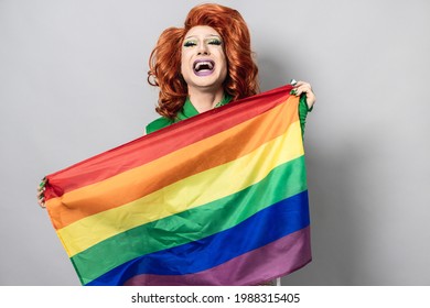 Happy drag queen holding rainbow flag - Lgbtq concept - Focus on face - Shutterstock ID 1988315405