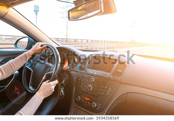Happy\
driver inside car at sunset. Young woman have fun ride trip travel\
on road in winter sunny day. Drive vacation\
concept