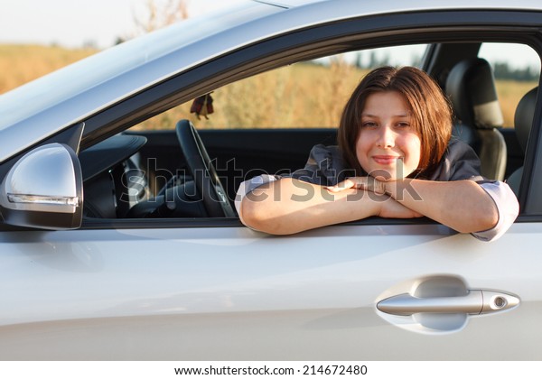 A happy driver\
leaning out of the window