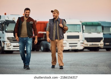 Happy drivers communicating while walking on truck parking lot. Copy space.