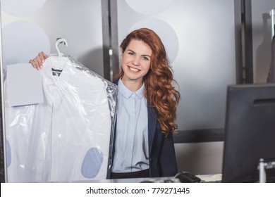 Happy Dry Cleaning Manageress Holding Shirt On Hanger Packed In Plastic Bag