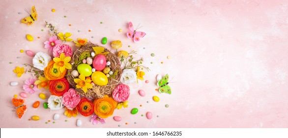Happy Easter Card. Creative Holiday Concept With Easter Eggs In Nest, Spring Flowers And Candy With Copy Space For Text.  Flat Lay Pattern.