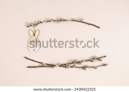 Happy Easter concept. Flat lay, top view of Easter eggs, willow plant branches, rabbit on isolated pastel beige background