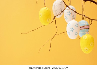 Happy Easter concept with lots of Easter eggs hanging on twigs on yellow. Copy space - Powered by Shutterstock