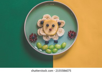 Happy Easter Concept On Plate, Sheep From Banana Fruit Full Of Vitamins On Plate, Isolated On Yellow And Green Backgrounds