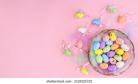 Happy Easter creative copy space background with colorful eggs and Easter decorations on pastel pink theme. Flat lay minimal