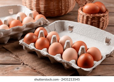 Happy Easter. Easter eggs. Chicken brown eggs close-up on the wooden table. A carton crate of fresh brown eggs. Organic chicken eggs in a egg carton. - Powered by Shutterstock
