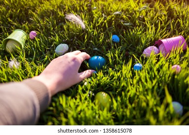 Happy Easter. Easter eggs hidden in spring grass. Woman holding egg