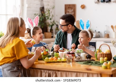 Happy Easter! Family Mother, Father And Children Paint Eggs For The Holiday