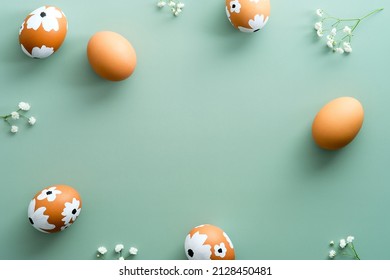 Happy Easter flat lay composition. Easter eggs with flowers on pastel green background. Easter card design, template.