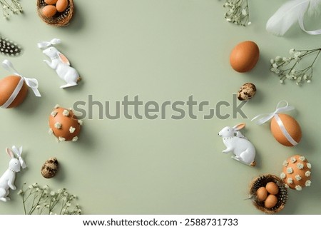 Happy Easter flat lay composition. Top view Easter eggs, quail eggs, gypsophila flowers, Easter bunny, feathers on pastel green background.