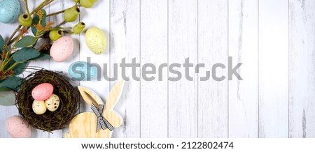 Happy Easter flatlay farmhouse theme banner styled with wood bunny, eggs and eggs against a white wood background with copy space. Sized to fit popular social media and web banner.